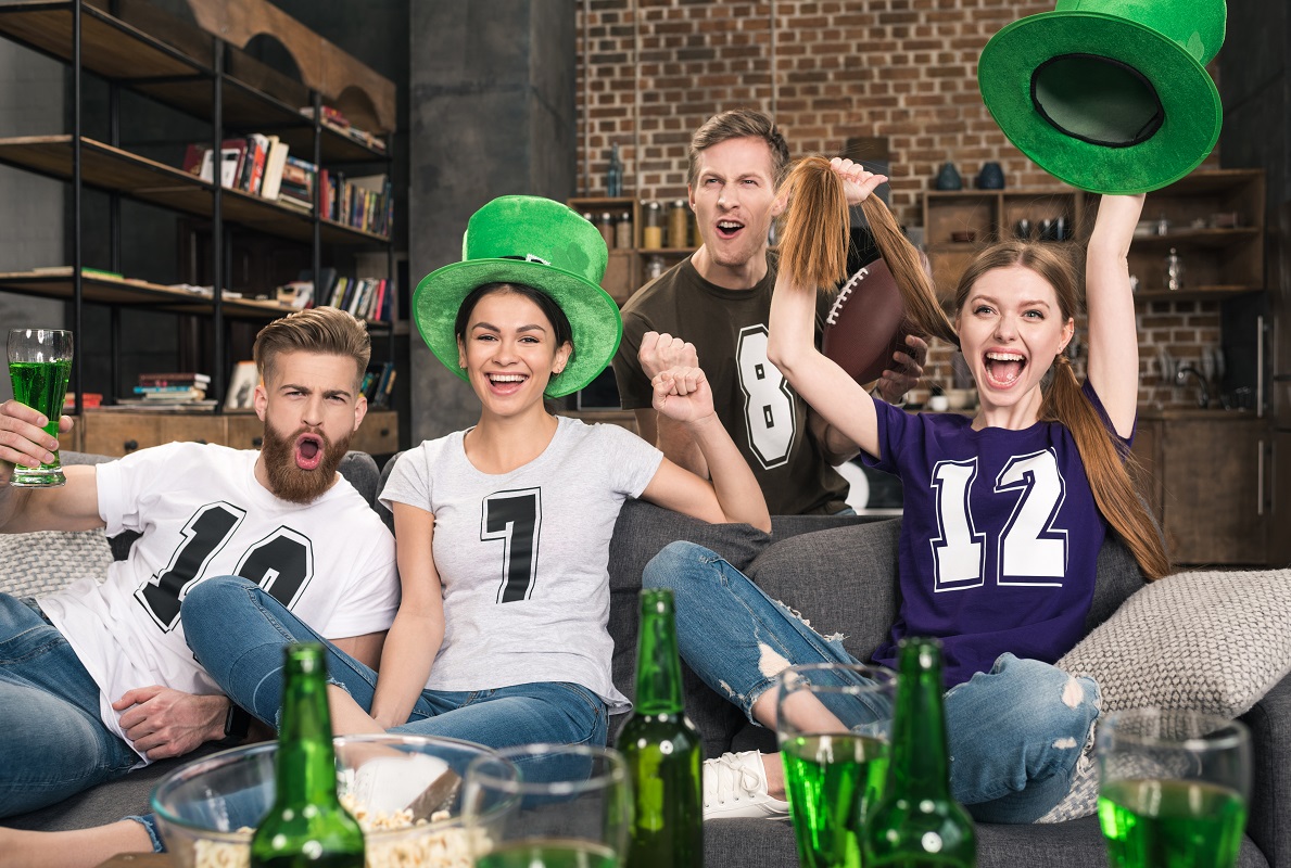 Szczęśliwi przyjaciele kibicujący w kapeluszach i koszulkach z nadrukiem