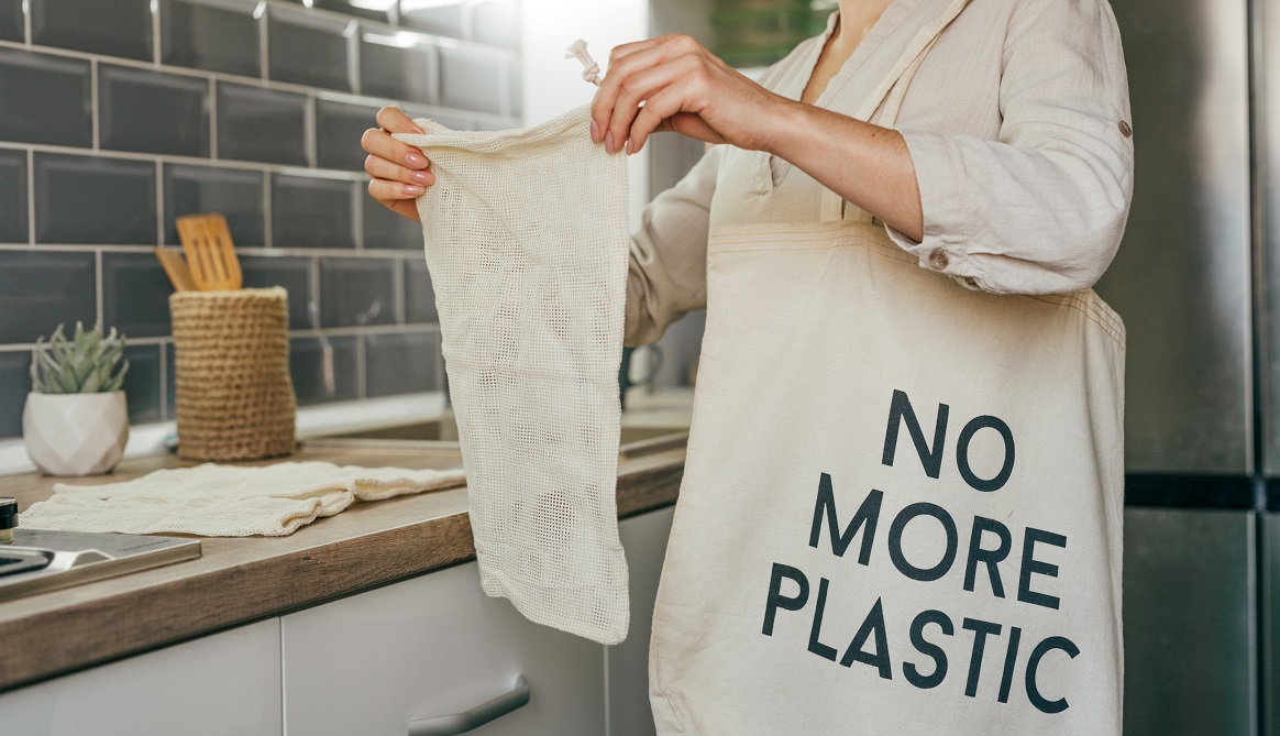 Młoda kobieta z bawełnianą torbą na zakupy "no more plastic"